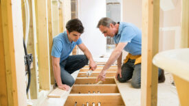 Plumber And Apprentice Fitting Central Heating