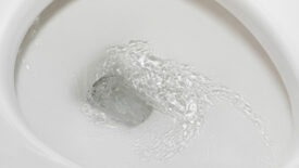 Motion blur of flushing water in toilet bowl. Plumbing, home repair and water conservation concept.