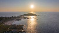 Overhead view of Quiberon Peninsula with the sun setting in the background.