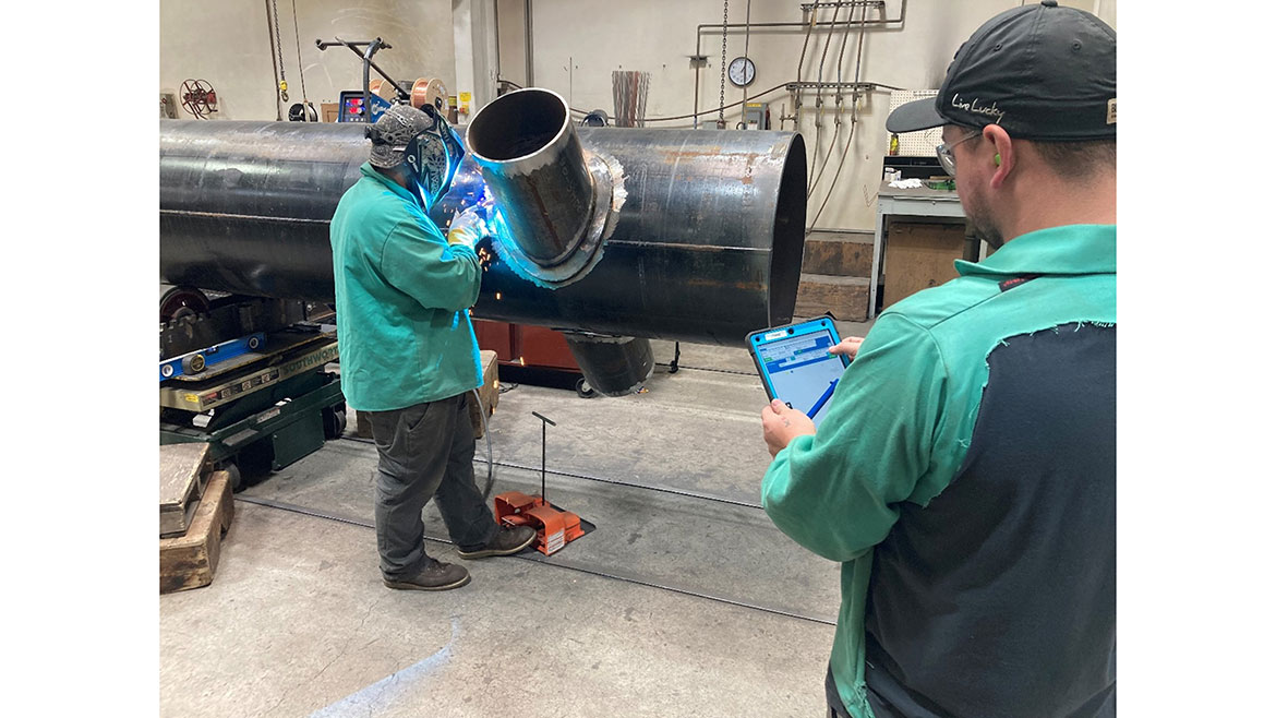 Two JH Kelly employees working on large piping.