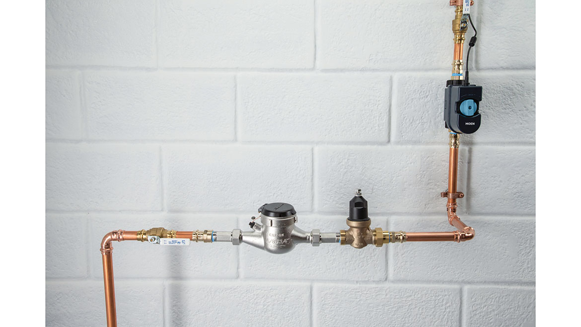 Moen plumbing pipes installation against a white brick wall.