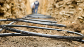 Workers Laying Geothermal Coils in an Underground Trench.