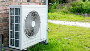 Environmentally Friendly Heat Pump Technology in Front of a brick house.