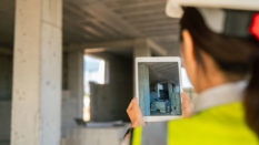 A female engineer using a digital tablet on a construction site.