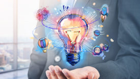 Businessman hand holding hologram of colorful light bulb as a concept of new idea for start up.