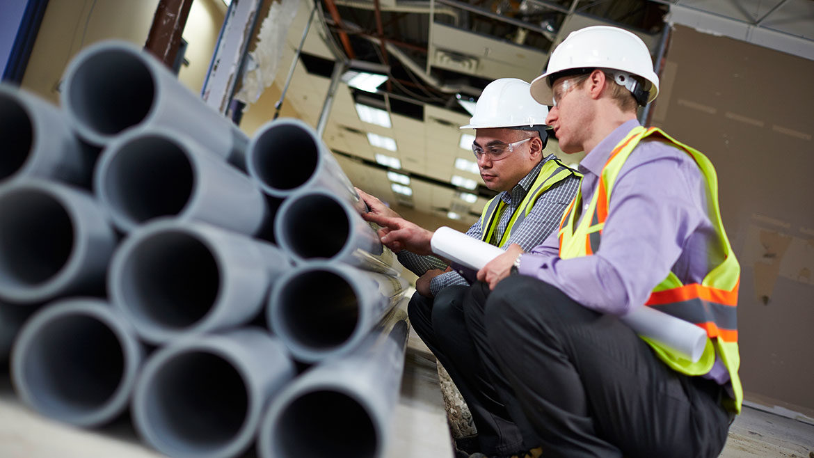 Employees inspecting pipes.