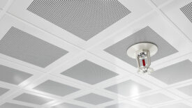 Fire Sprinkler on a White Ceiling With Perforated Tiles