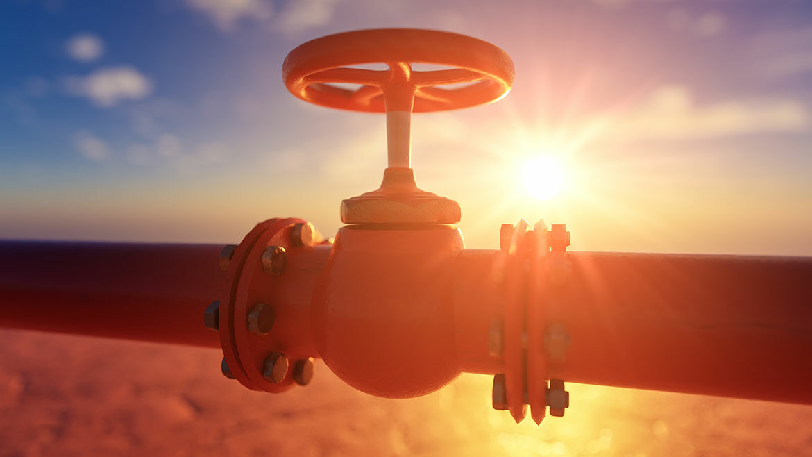 Gas pipe with red valve on sunset background.